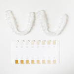 two dental whitening trays and a palette for tooth color